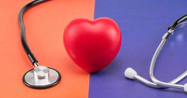 corazón de juguete y un estetoscopio sobre un fondo de color. concepto de salud. cardiología - cuidado del corazón foto