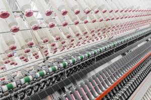 Maquinaria y equipo en el taller para la producción de hilo. fábrica textil industrial foto