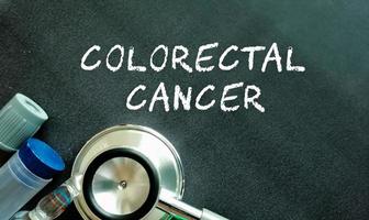 palabra de cáncer colorrectal, palabra de término médico con conceptos médicos en pizarra y equipo médico foto