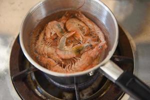 Boiled shrimps in a hot pot on the stove, shrimp prawn cooking menu food concept photo