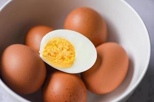 menú de huevos pelados alimentos huevos cocidos en un bol y cáscara de huevo, cortados a la mitad yemas de huevo para cocinar una alimentación saludable foto