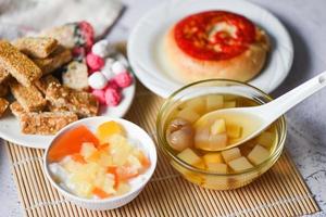 Chinese desserts chinese pastry bean cake, Snack mix nuts candies sweets sugar nuts sesame seeds coated beans puffed rice, milk pudding fruit salad longan juice bowl in chinese new year festival food photo