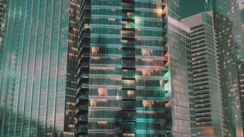 arquitectura nocturna de rascacielos con fachada de cristal