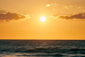 Yellow warm sun over deep blue sea at scenic sunset sky, endless sea in warm bright sunlight photo
