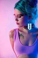 portrait of a bright woman with blue hair in transparent glasses in neon light photo