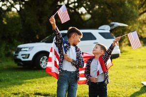 Two brothers with USA flag. America holiday. Proud to be children of country. photo