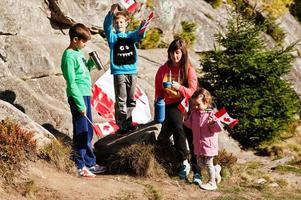 feliz dia DE CANADA. la familia de la madre con tres hijos celebra una gran celebración de la bandera canadiense en las montañas. foto