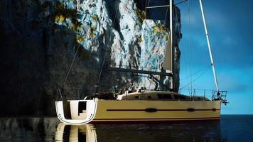 White yacht anchored in a bay with rocky cliffs video