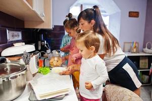 Mother with kids cooking at kitchen, happy children's moments. photo