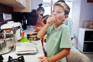 Kids cooking at kitchen, happy children's moments. photo