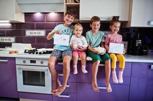 Kids cooking at kitchen, happy children's moments. Four kid, large family. photo