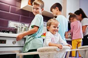 Mother with kids cooking at kitchen, happy children's moments. photo