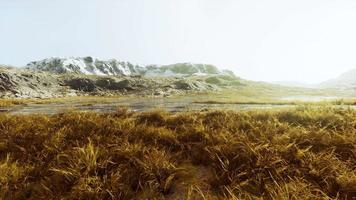 wide valley steppe with yellow grass under a cloudy sky on the mountain ranges video