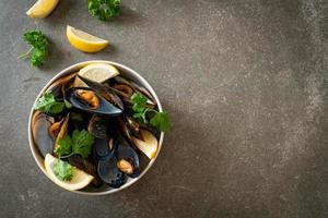 mejillones con hierbas en un bol con limón foto