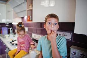 Kids cooking at kitchen, happy children's moments. Brother with sister together. photo