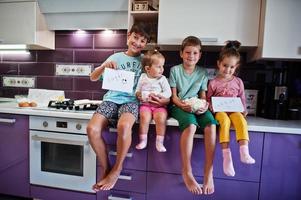 Kids cooking at kitchen, happy children's moments. Four kid, large family. photo