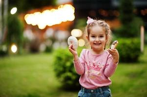 niña con donuts en el patio de la tarde. sabrosa deliciosa comida de donas. foto