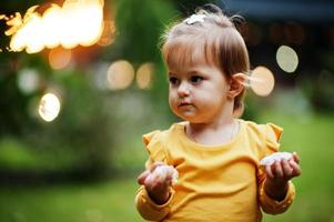 niña con donuts en el patio de la tarde. sabrosa deliciosa comida de donas. foto