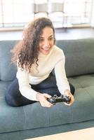 mujer laitina jugando videojuegos con las manos sosteniendo el joystick foto