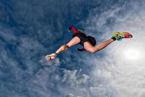 Athletic girl jumps while running in the mountains photo