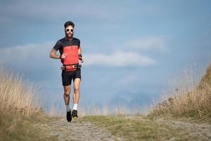 An athlete runner with a beard trains on a mountain road photo