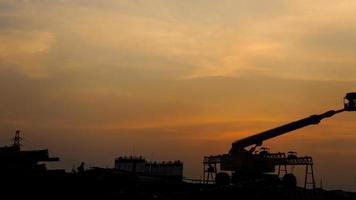 Silhouette of fly over construction site, sunset background photo