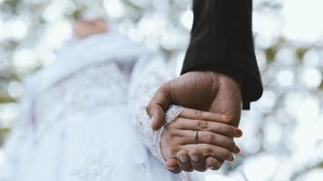 Married couple holding hand at ceremony wedding