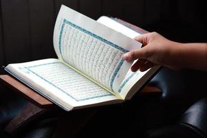 Close-up of the hand turning a new page of the quran photo