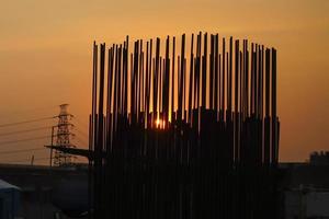 silueta de volar sobre el sitio de construcción, fondo de puesta de sol foto