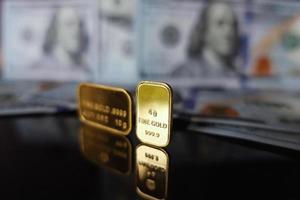 Close up pure gold bar on the black glass surface with reflection photo