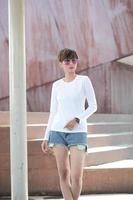 Mock up of white long sleeve t shirt and short pants wearing by beautiful stylish short hair woman in urban background photo