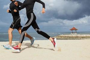 pareja trotando afuera, corredores entrenando al aire libre haciendo ejercicio en la naturaleza. salud, ejercicio, concepto de pérdida de peso. pareja haciendo jogging en la playa. foto