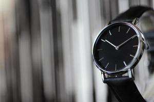 reloj de pulsera negro, con esfera cromada. y fondo borroso foto