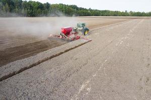 MINSK, BELARUS  SEPTEMBER 2020  tractor sows in the field top and back view. photo