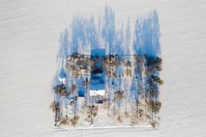 Lonely house in the middle of a snow-covered field top view. photo