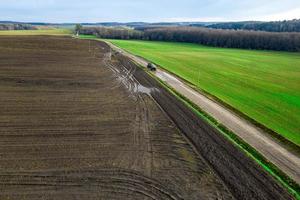 panorama de la vista superior del campo de un agricultor. el tractor hace fertilizantes orgánicos.