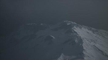 espectacular montaña rocosa oscura con parches de nieve en la tormenta video