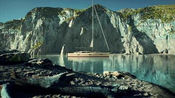 yacht blanc ancré dans une baie aux falaises rocheuses video