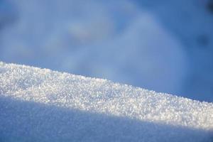 Light and shadow in the snow. Snowy texture on a sunny day. photo