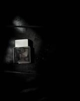 Perfume bottle on dark grungy background. photo