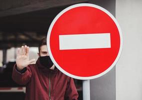 Man in protective mask showing gesture stop. photo