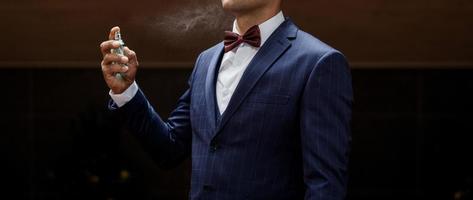 man in suit using perfume photo