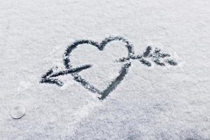 corazón en la nieve con una flecha foto