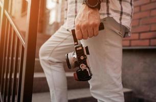 el hombre sostiene una cámara digital foto