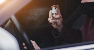 Driver spraying antibacterial sanitizer spray photo