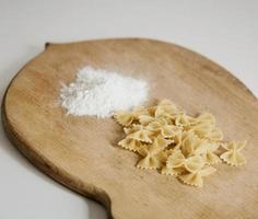 raw pasta on wooden board photo