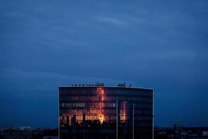 Modern glass building with reflected photo