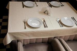 White plate, cutlery and napkin on table photo