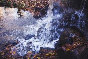 piedras mojadas entre la corriente de agua foto