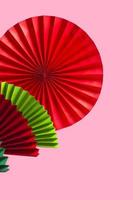 Pink background with paper multicolored fans with copy space for text. Vertical Format. photo